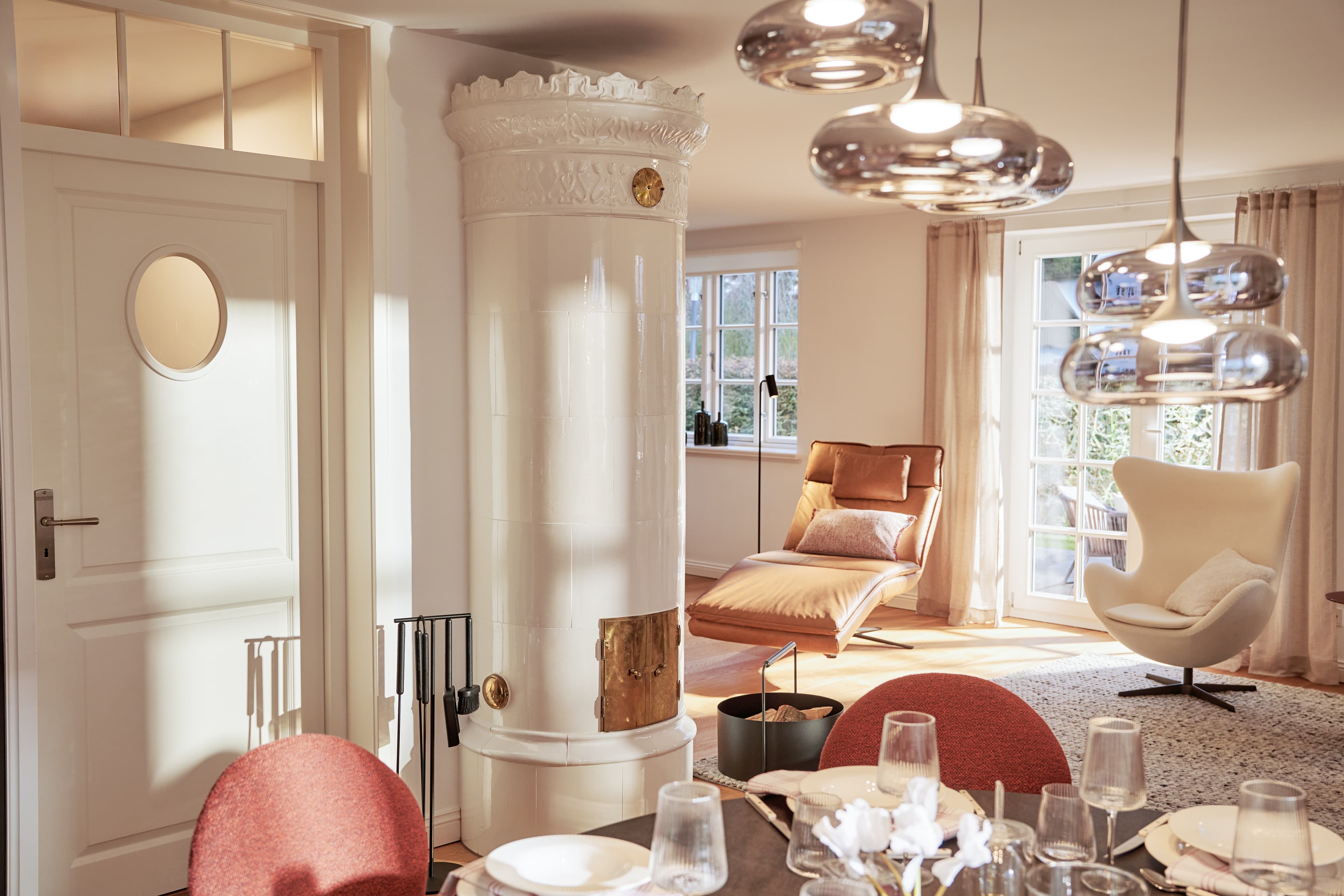 Der handgefertigte weiße Kachelofen mit Verzierungen und goldenen Highlights