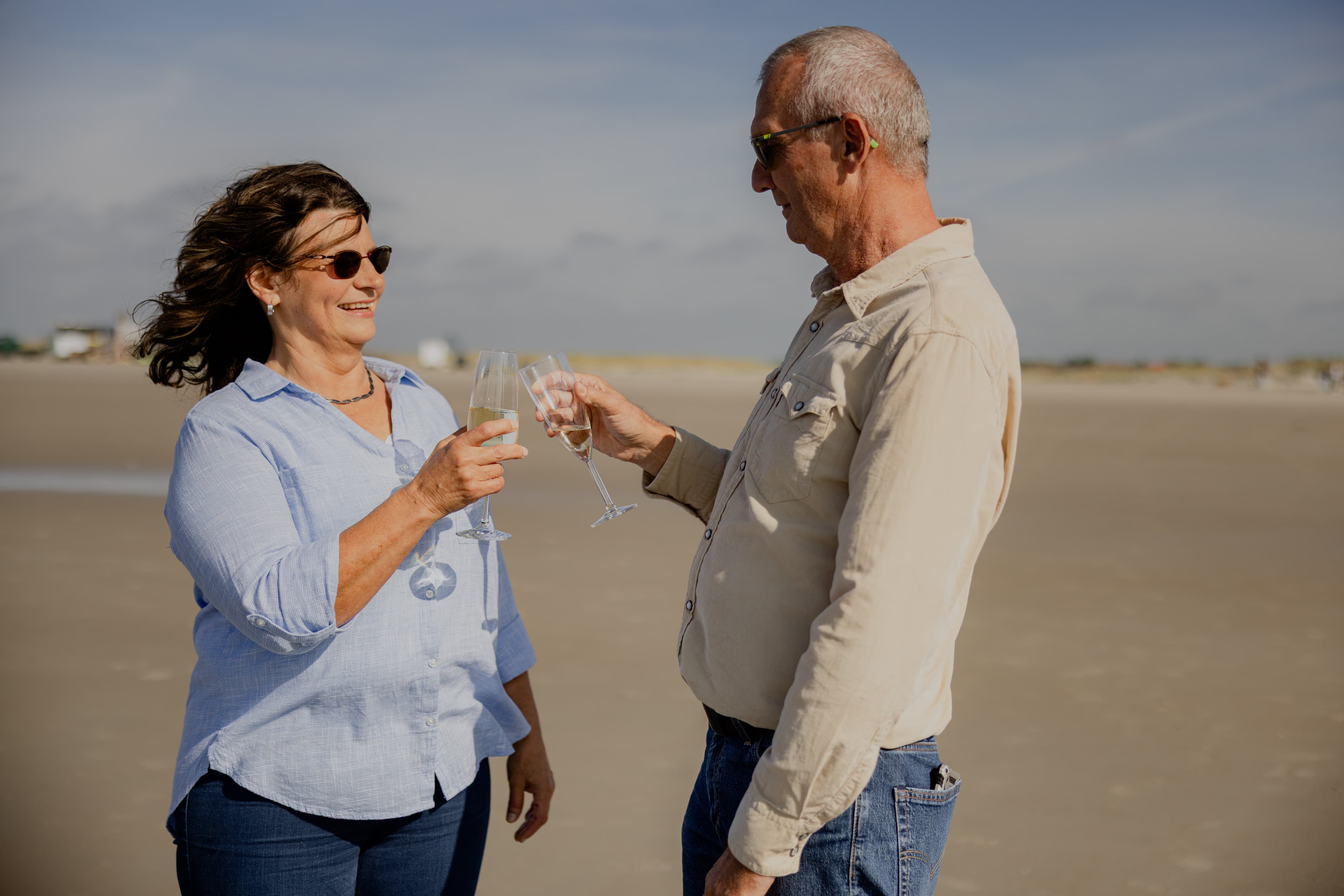 Thomas, Gewinner des Nordsee-Traumhauses und seine Frau am Strand von SPO mit einem Glas Sekt